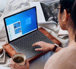 Eine Frau nutzt Remote Work und hat ihren Laptop im Bett auf einem Tablett mit Füßen. Bild: Unsplash/Windows